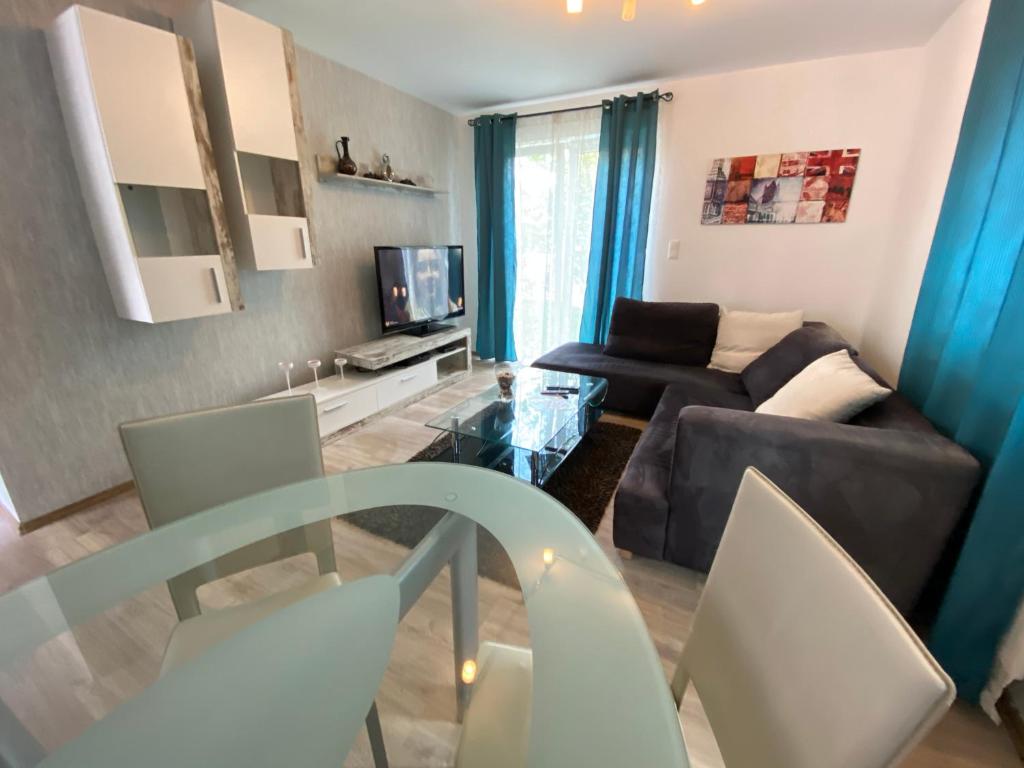 een woonkamer met een bank en een tafel en stoelen bij city apartment in Graz