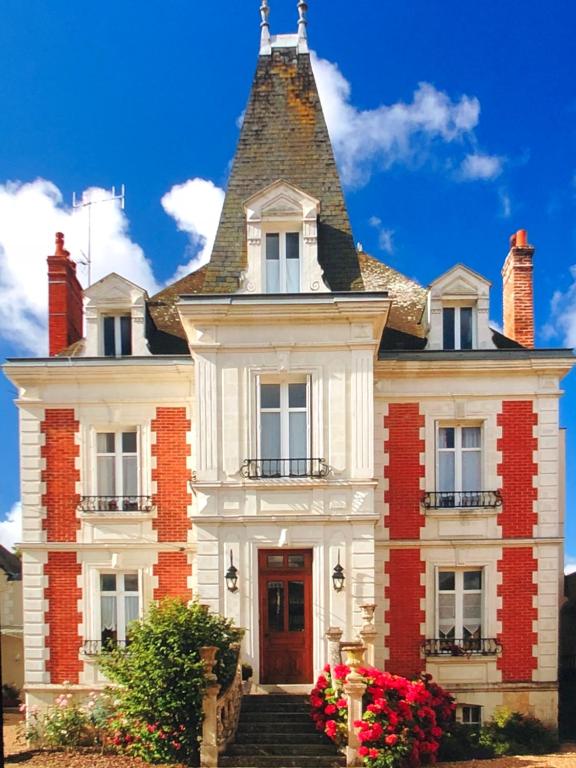a red brick building with a clock on the front of it at Manoir Du Parc (Adults only) in Amboise