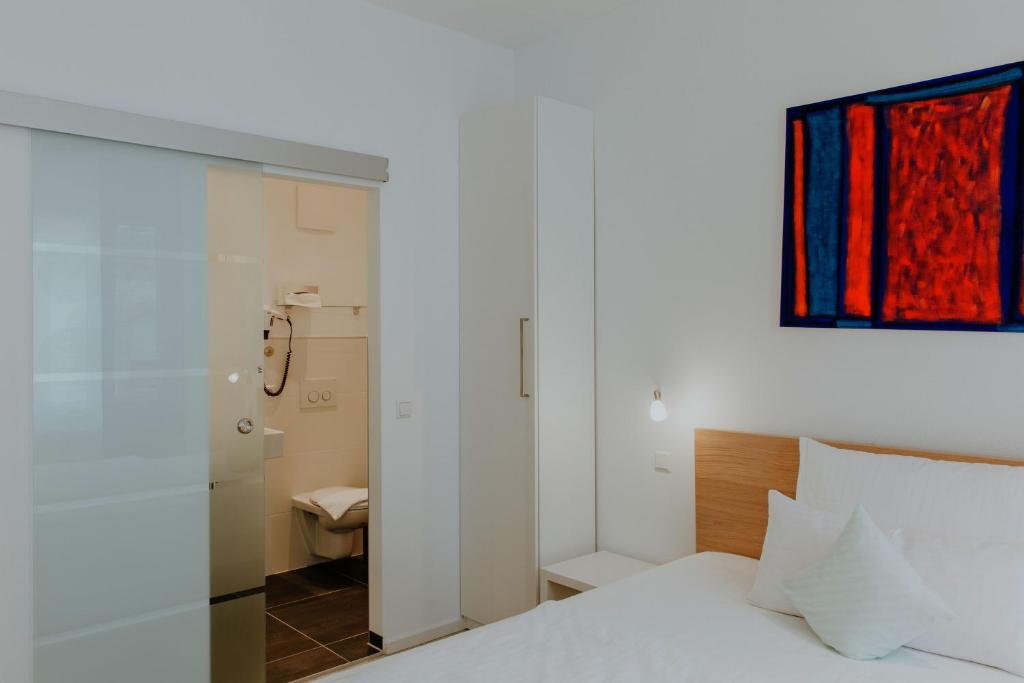 Postel nebo postele na pokoji v ubytování Hotel Barbarossa Karlsruhe Stadtmitte