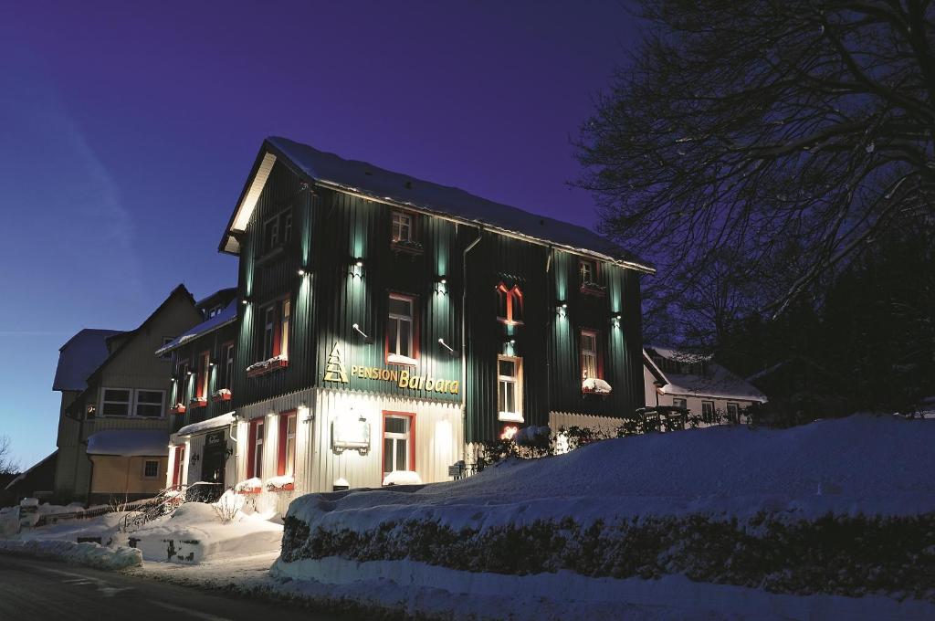un edificio con luces de Navidad en la nieve en Pension Barbara, en Schierke
