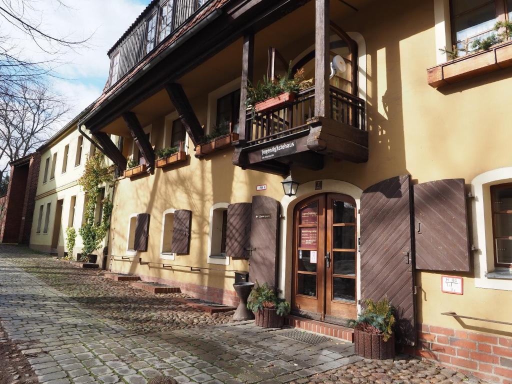 a building with a balcony and a door on a street at Jugendgästehaus Cottbus in Cottbus