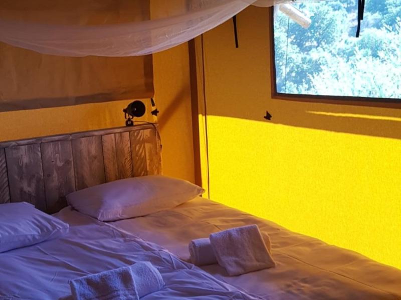 Tempat tidur dalam kamar di Safaritent Glamping Mar Y Sierrra