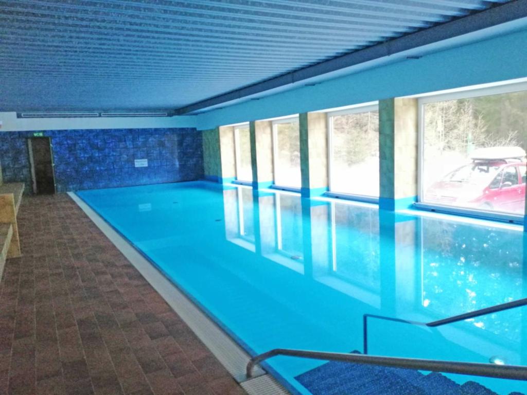 a large swimming pool with blue walls and windows at Apartment Gerlitzen Ossiachersee - Haus Enzian in Treffen