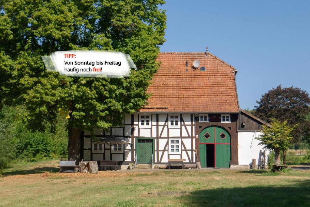 una pequeña casa con un cartel delante en Suffelmühle, en Bad Driburg