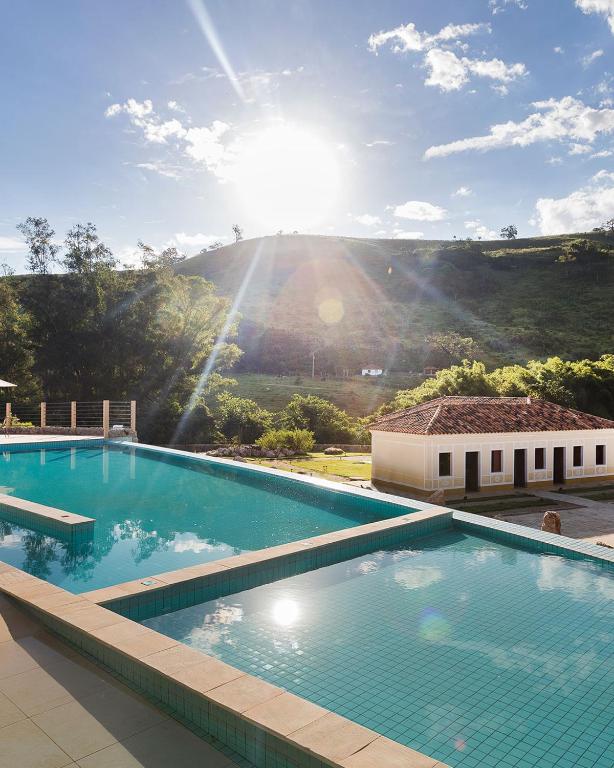 a large swimming pool with a view of a mountain at Hotel Fazenda Terra dos Sonhos in Bueno Brandão