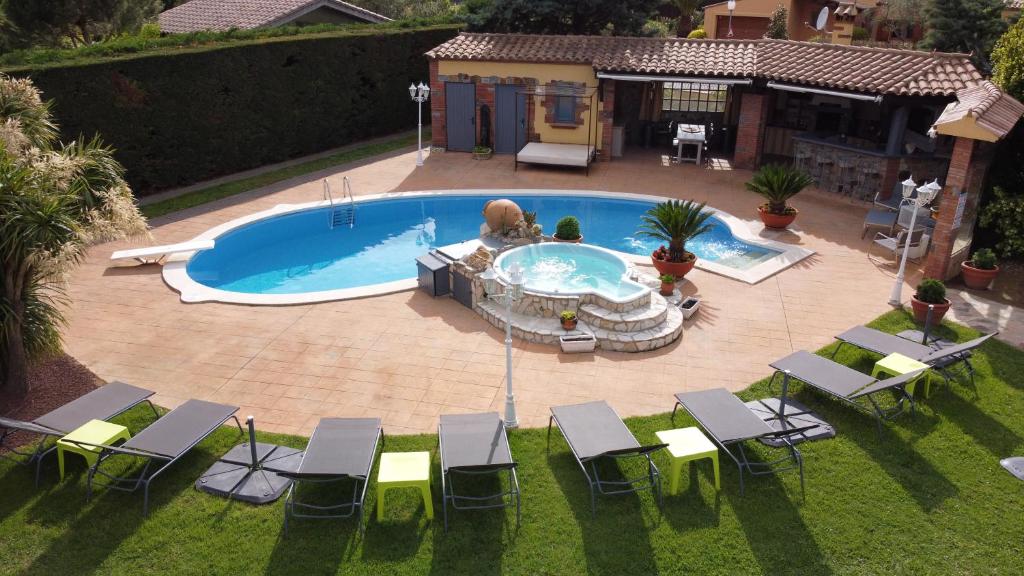 eine Aussicht über einen Pool mit Stühlen und einem Tisch in der Unterkunft La Villa Du Golf Peralada in Peralada