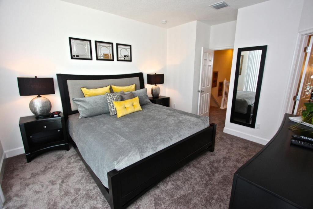 a bedroom with a large bed with yellow pillows at 17517 Dream in Orlando