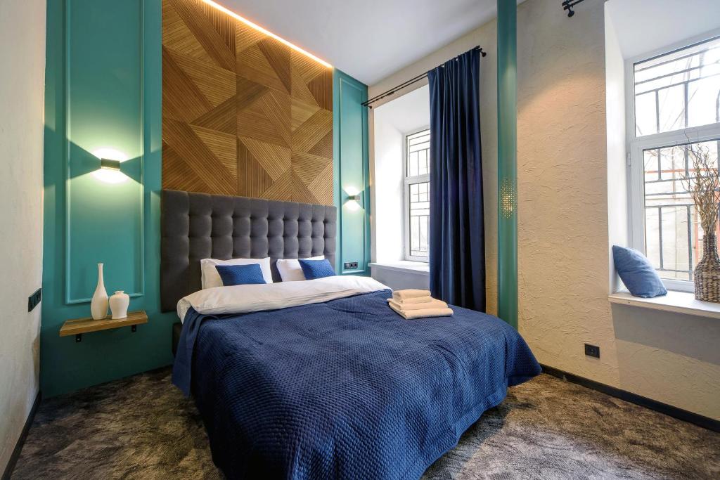 1 dormitorio con 1 cama con paredes azules y verdes en Hotel Buninn, en Odessa
