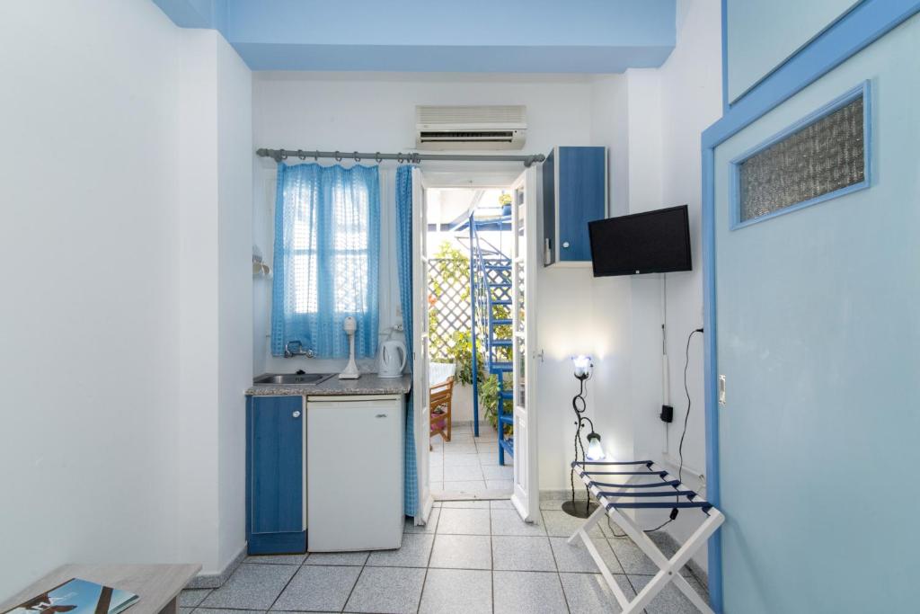 cocina azul y blanca con fregadero y nevera en Kamara, en Tinos