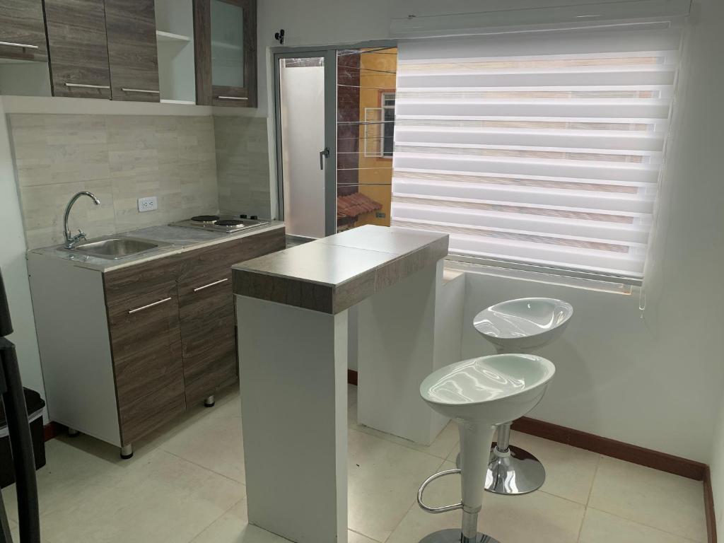 cocina con encimera, fregadero y taburete en Apartamento en el Norte de Bogota, en Bogotá