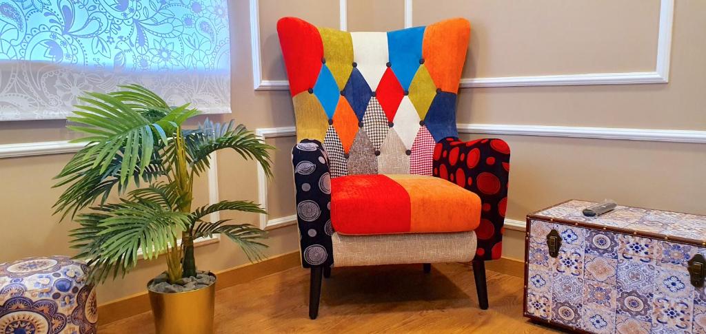 a colorful chair in a room with a plant at Afonso Galo Guest Apartments II in Almada