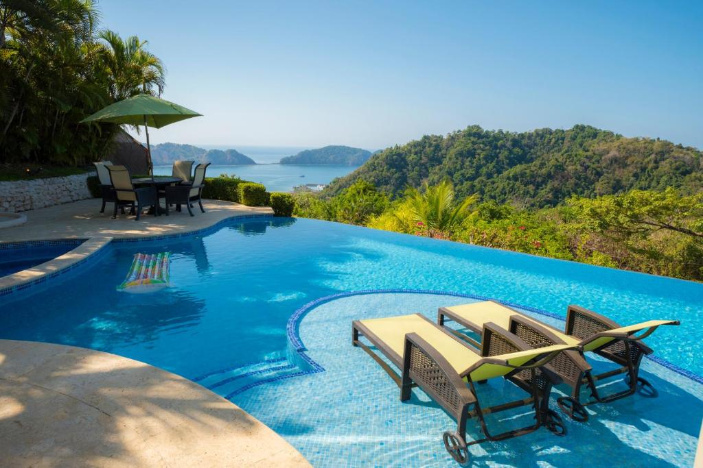 耶拉杜拉的住宿－Los Suenos Resort Casa Puesta del Sol by Stay in CR，一个带椅子和桌子的景观游泳池