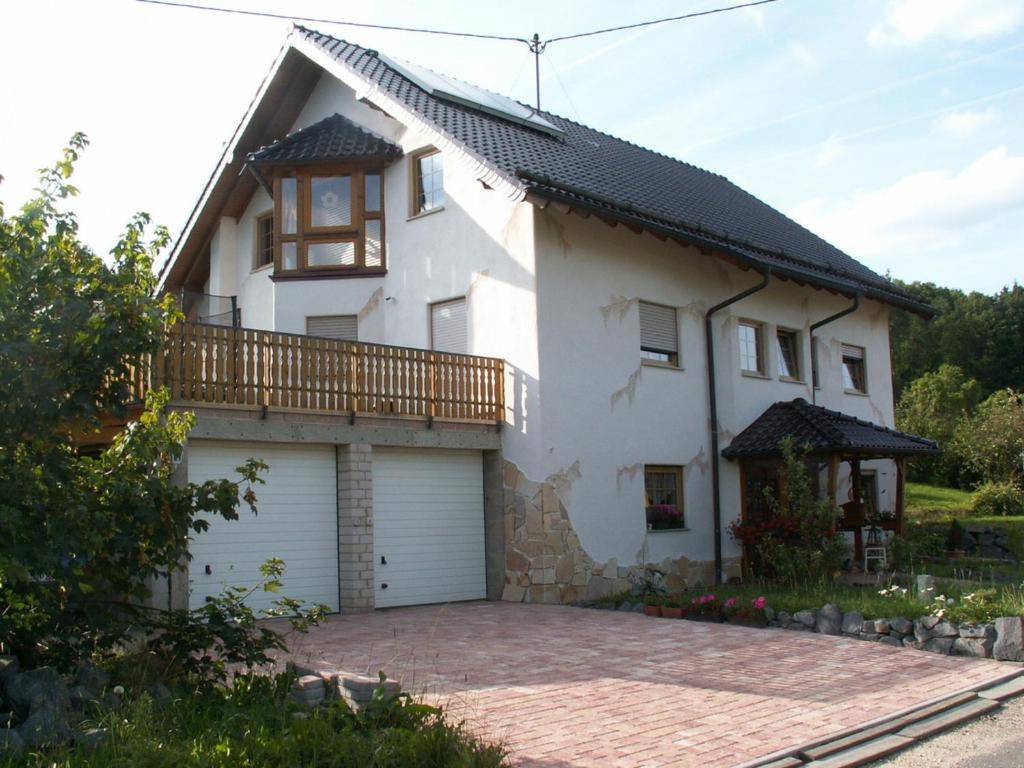 a white house with a balcony and a driveway at Gästehaus Lara in Wimbach