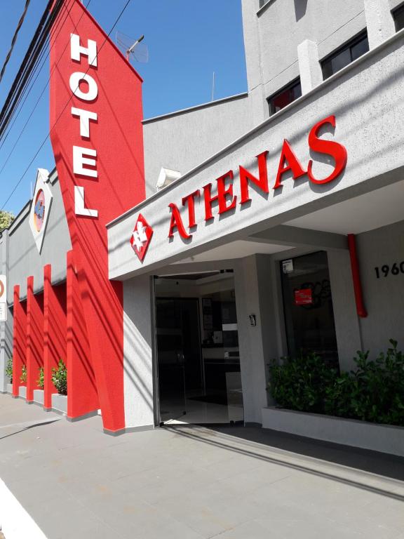 un edificio con una señal roja en la parte delantera. en Hotel Athenas e Convenções, en Araçatuba