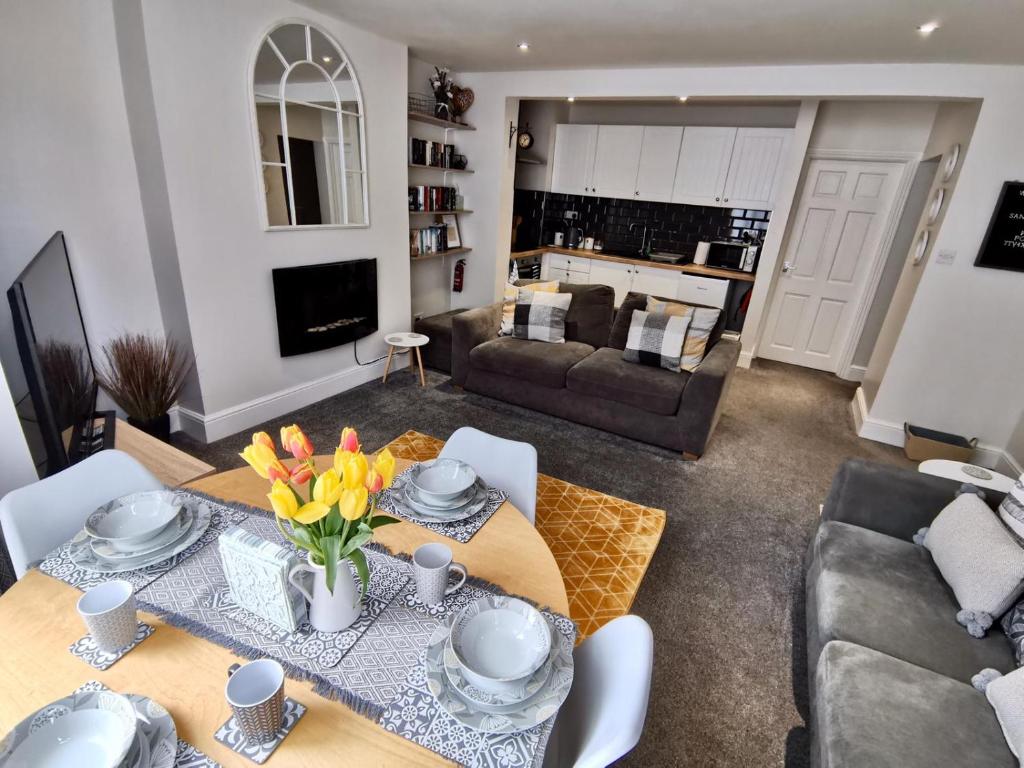 uma sala de estar com uma mesa com flores em Sandalwood Apartment - Saltburn by the Sea em Saltburn-by-the-Sea