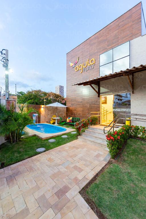 a swimming pool in front of a building at Pousada da Águia in Natal