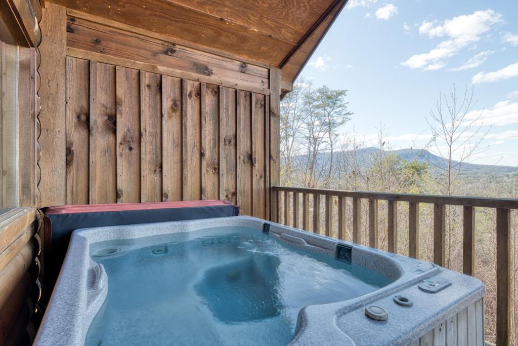 a hot tub on the deck of a cabin at All About Romance by Venture Smoky Mountains in Henderson Springs