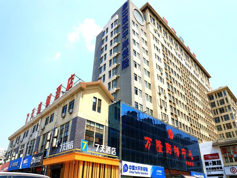 wysoki budynek z czerwonym napisem na boku w obiekcie 7Days Inn Qingzhou Pingzhangfu Store w mieście Weifang