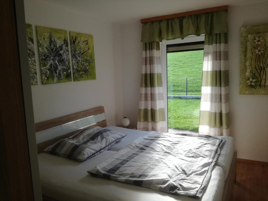 Schlafzimmer mit einem Bett und einem Fenster in der Unterkunft Ferienhaus Mitterbauer in Oberhofen am Irrsee
