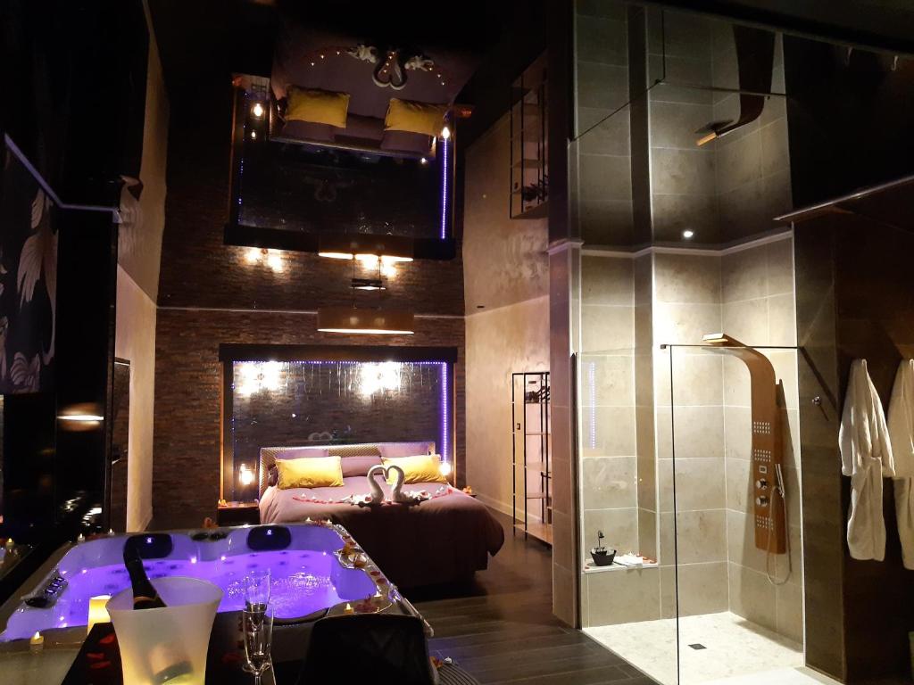 uma casa de banho com uma banheira e um quarto com uma cama em Suite Calypso em Agde