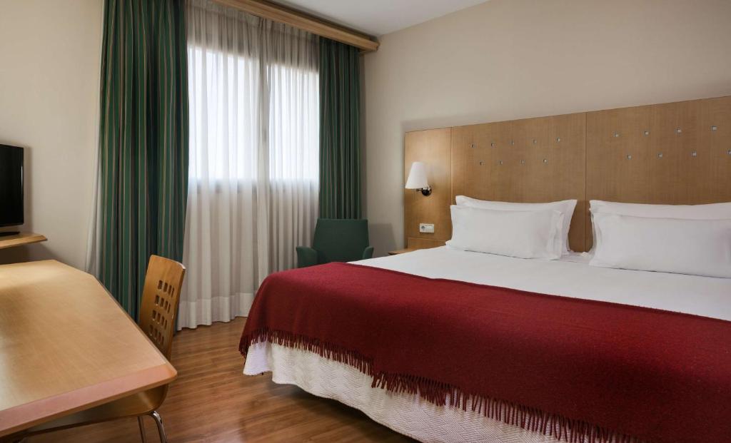 um quarto de hotel com uma cama grande e uma janela em Hotel Logroño em Logroño