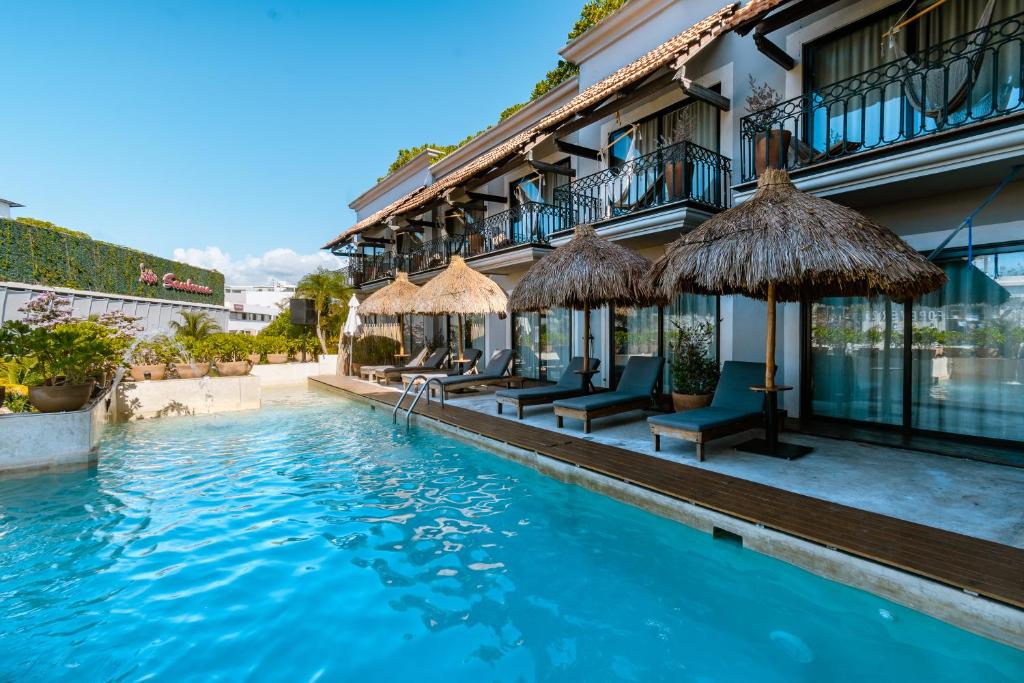 a hotel with a swimming pool in front of a building at Caribbean Paradise Hotel Boutique & Spa by Paradise Hotels - 5th Av Playa del Carmen in Playa del Carmen