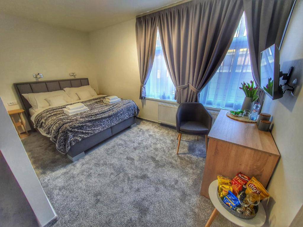 um quarto com uma cama, uma secretária e 2 janelas em Penzion Gemer em Jeseník