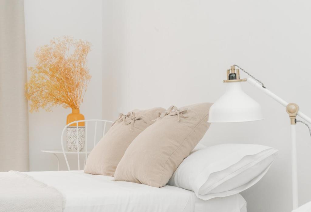 Dormitorio blanco con cama blanca y almohadas en Dulces Dreams Boutique Hotel, en Málaga