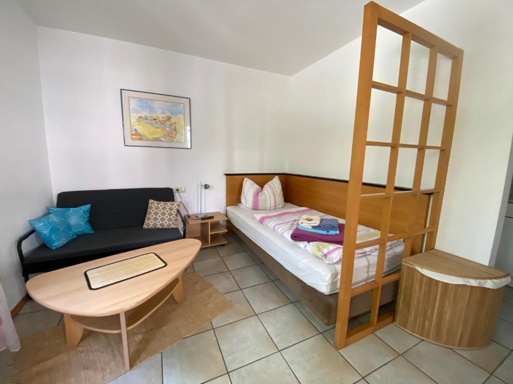 ein kleines Zimmer mit einem Bett, einem Sofa und einem Tisch in der Unterkunft Apartmenthaus Home24 in Chemnitz