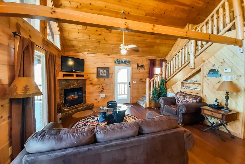 un soggiorno con divano e camino in una cabina di A Bearz Haven a Sevierville