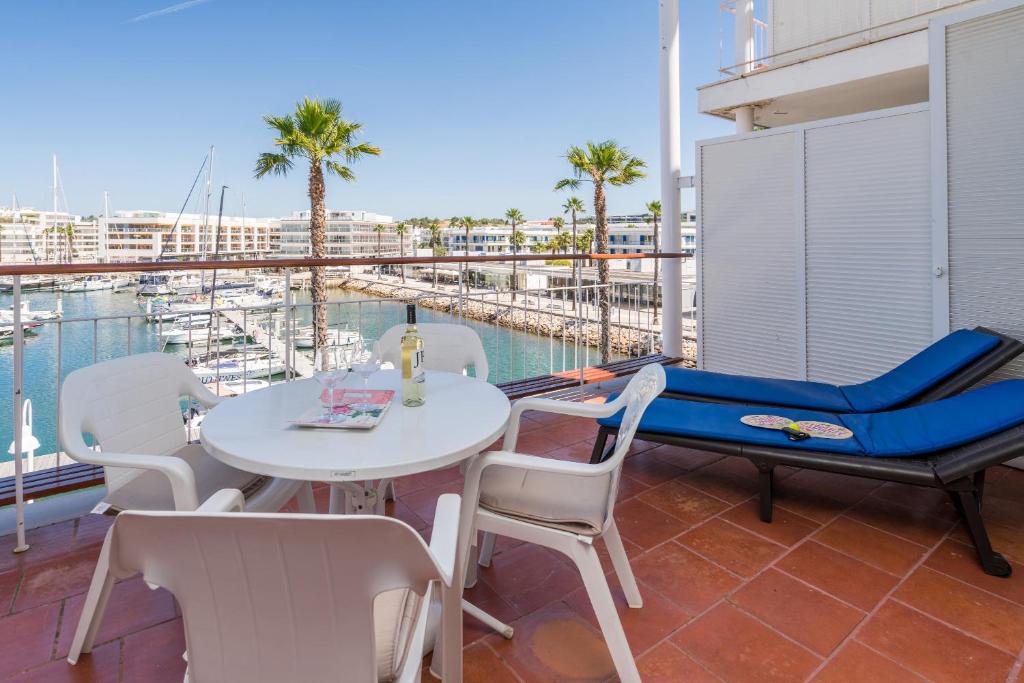 een balkon met een tafel en stoelen en uitzicht op een haven bij Marina-L in Lagos