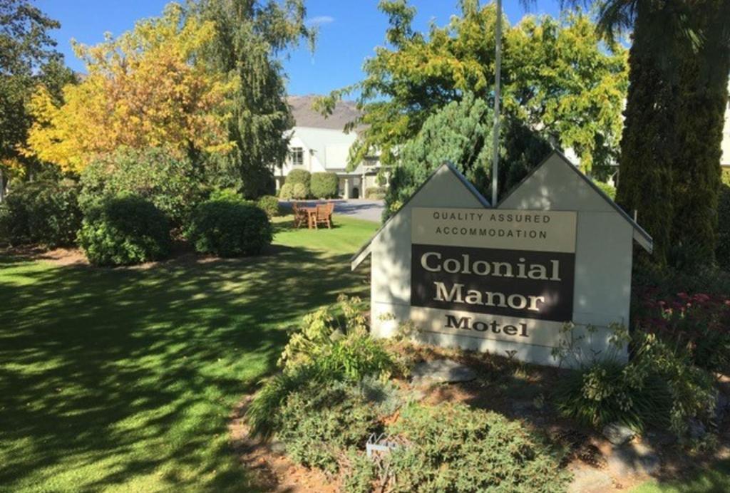 znak dla kolonialnego dworku w ogrodzie w obiekcie Colonial Manor Motel w mieście Cromwell