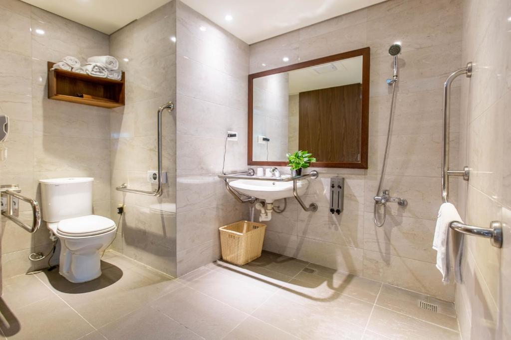 a bathroom with a toilet and a sink and a shower at Jia Hsin Garden Hotel in Tainan