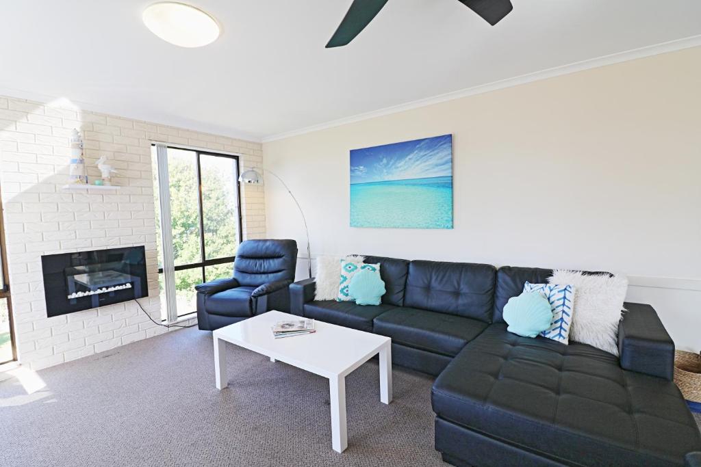 a living room with a couch and a table at Capri Apartments in Merimbula