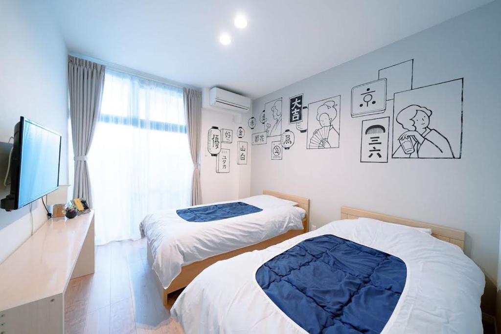 - une chambre avec 2 lits, une télévision et une fenêtre dans l'établissement カモンイン 東寺東, à Kyoto