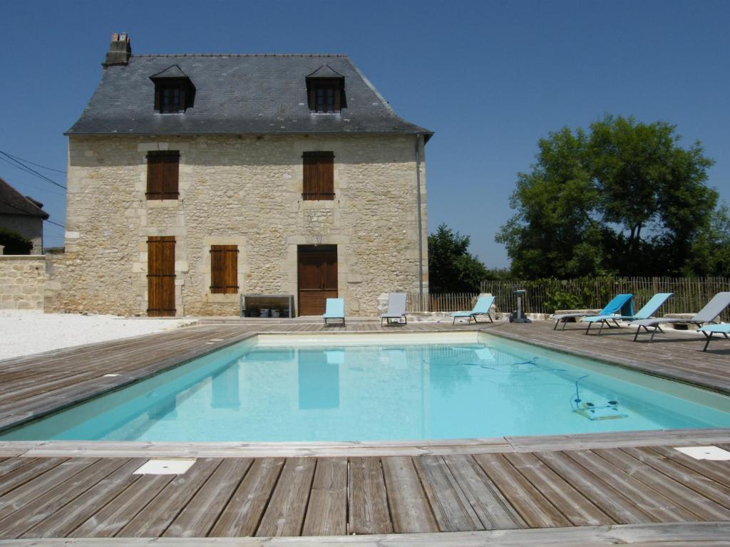 - une piscine en face d'un bâtiment en pierre dans l'établissement LOU CHASTEL, DEMEURE PERIGOURDINE CLIMATISEE avec PISCINE PRIVEE et CHAUFFEE, à La Bachellerie