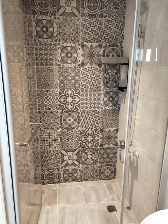 a bathroom with a shower with a tile wall at Light Blue Hostel in Hengchun South Gate