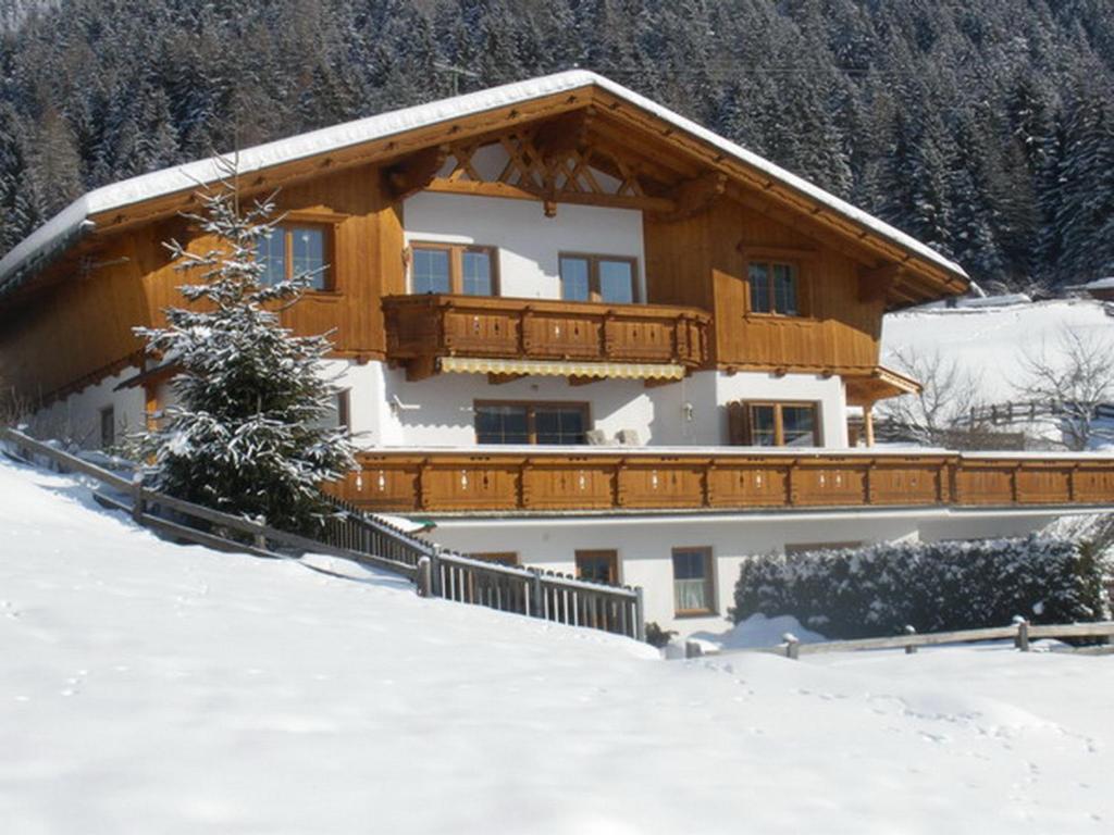 a house with a balcony in the snow at Appartement Susanne in Neustift im Stubaital