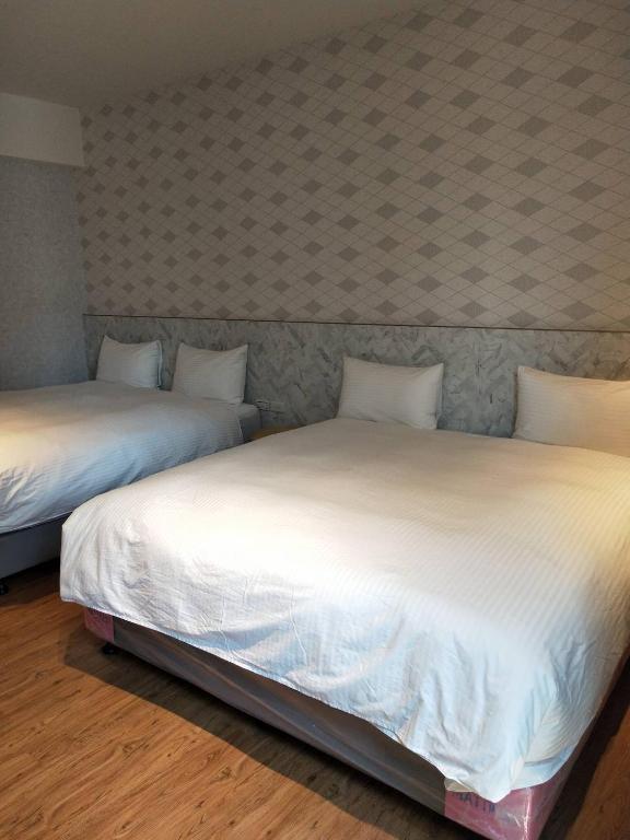 two beds sitting next to each other in a room at Light Blue Hostel in Hengchun South Gate