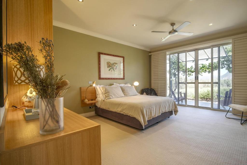 a bedroom with a bed and a large window at Belle Bois, Capertee Valley in Glen Alice