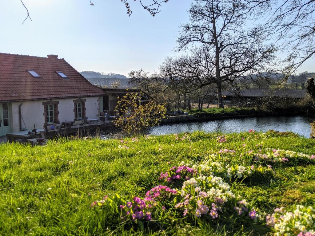 a garden with flowers in front of a house at Ancien moulin Créancey in Créancey