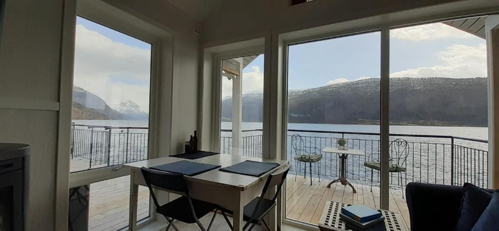a room with a balcony with a view of the water at Fjord Paradise Stryn in Stryn