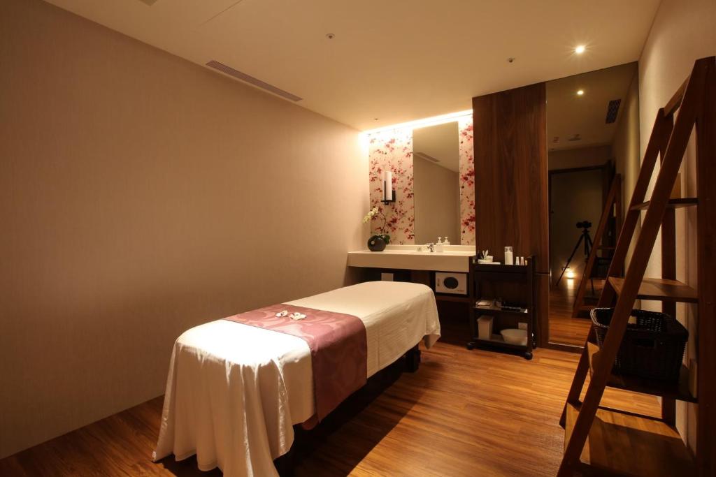 a bedroom with a bed and a sink and a mirror at Beitou Hot Spring Resort in Taipei