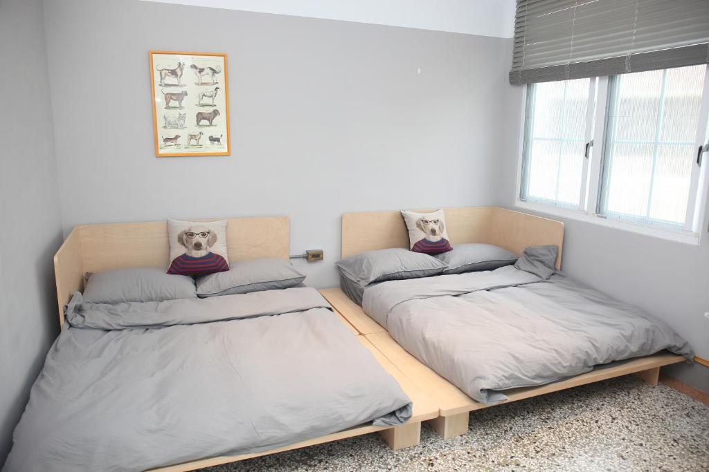 a bedroom with two beds and a window at Spring Guest House in Tainan