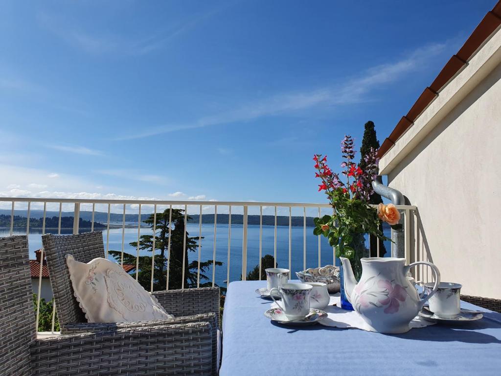 a table on a balcony with a view of the ocean at Vila Rosa in Portorož