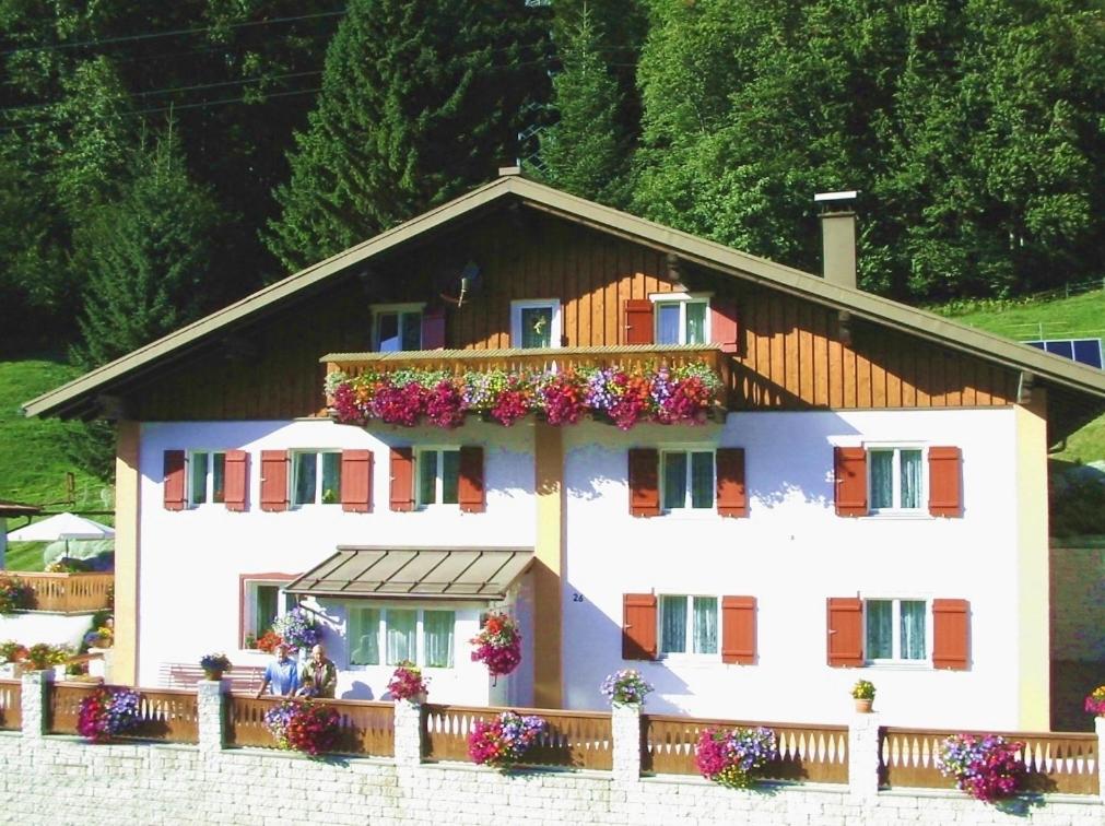 a white house with flowers on the balcony at Haus Jochum in Langen am Arlberg