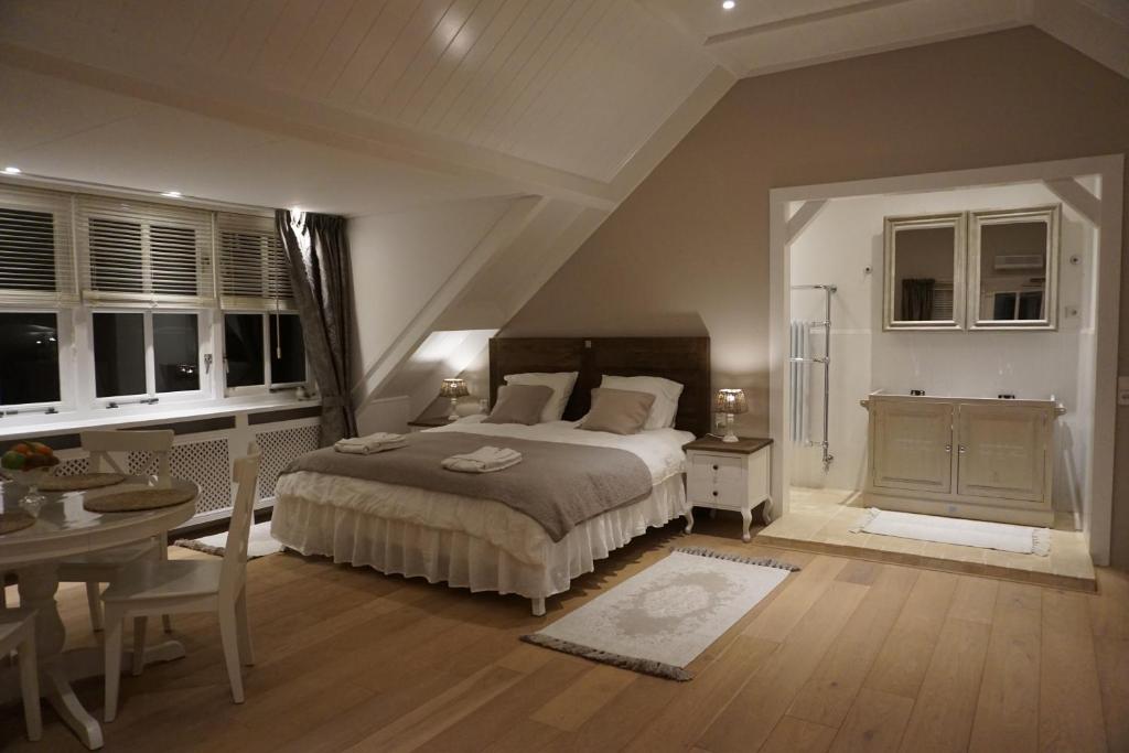 a bedroom with a large bed and a table and chairs at 't Gorsje in Goedereede