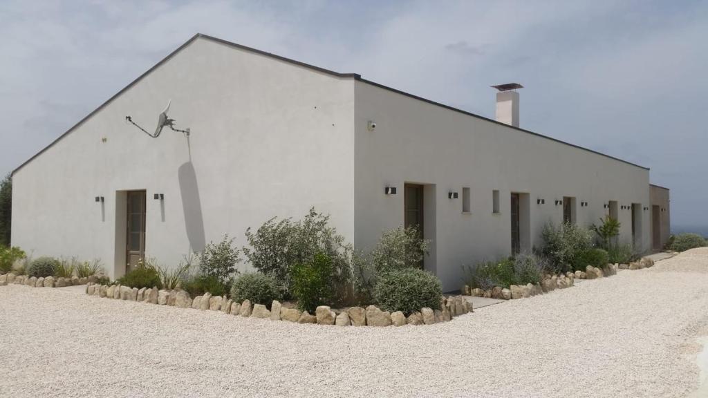 un edificio bianco sul lato di una spiaggia di Serra Niedda Resort & Agriturismo a Sorso