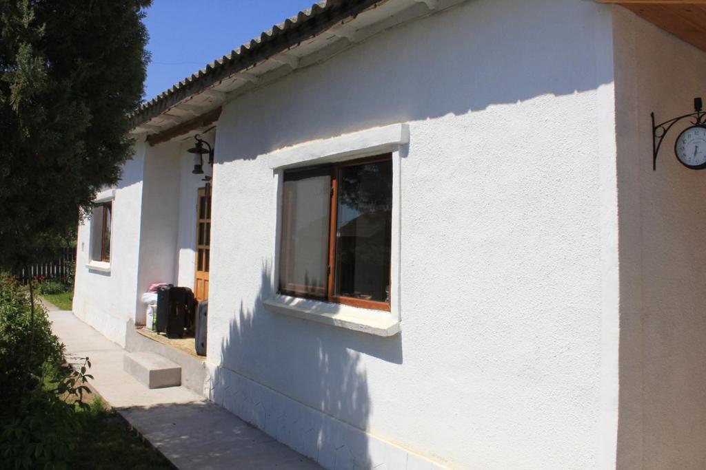 a white building with a window on the side of it at Casa de Vacanta Sarinasuf in Sarinasuf
