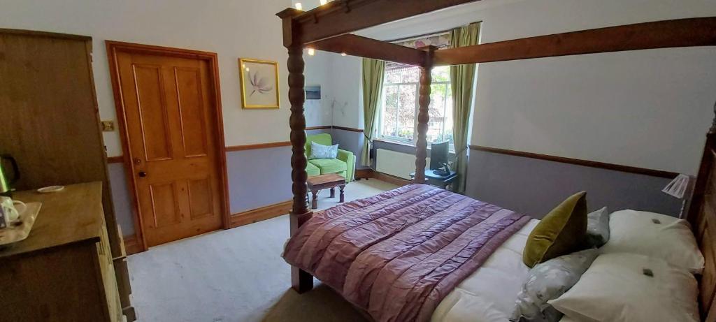 ein Schlafzimmer mit einem Bett mit einem Holzrahmen in der Unterkunft Laurel Cottage in Windermere